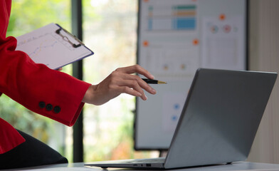 Businesswoman searching through laptop for online real estate on office desk