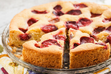 pie with plums and slice and cup with coffee.