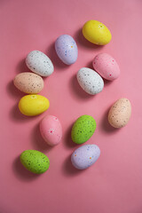 Painted quail eggs on a pink background. Easter decorations. 