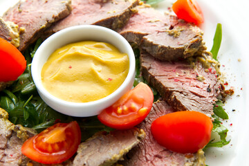 Closeup of roast beaf with honey mustard and vegetables