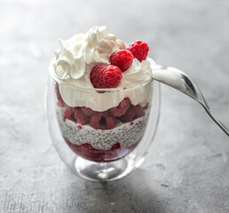 Dessert from yogurt with chia seeds and  raspberries on a grey background