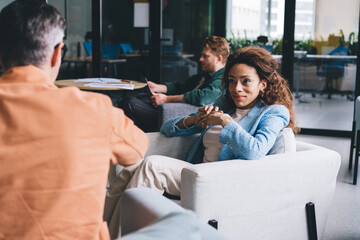 Couple sitting on armchair and having conversation