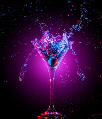 Colourful cocktail in glass with splash on the dark background
