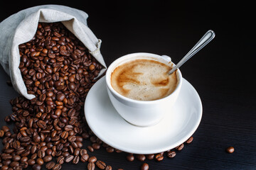 Coffee cup and coffee beans on kitchen table. Top view.