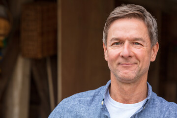 Portrait shot of an attractive, successful and happy middle aged man male wearing a blue shirt...