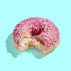 pink donut with glaze on turquoise pastel background