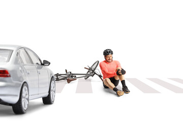 Mature male bicycle rider sitting on a street and holding his painful knee