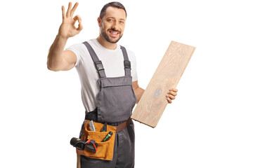 Carpenter holding a wooden floor beam and gesturing ok sign