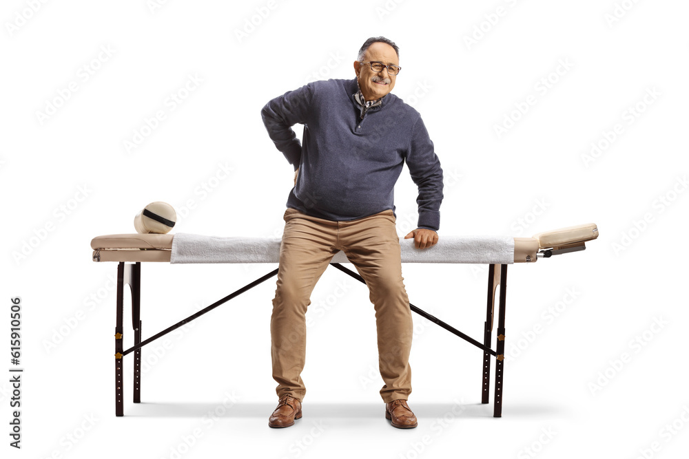 Poster mature man with a stiff back sitting at a massage table