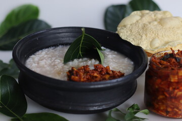 Kanji and Kadumanga. Rice gruel prepared with Matta rice. Served in earthen pot in a traditional way with spoon made of jackpot tree leaf.