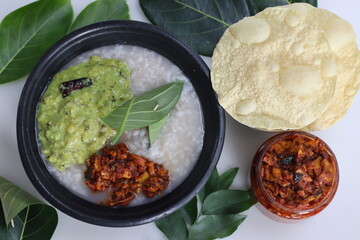 Kanji and Kadumanga. Rice gruel prepared with Kerala Matta rice. Served in earthen pot with jackpot tree leaf cutlery.