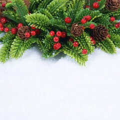 Christmas wreath with pine cones and berries nestled in snow