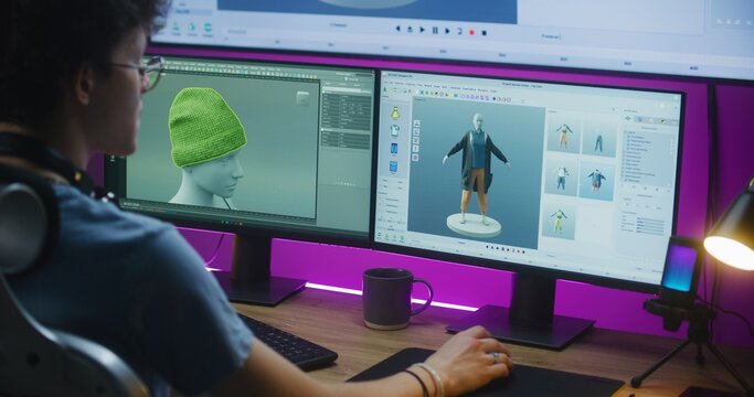 Young 3D designer creates video game character or clothes, works remotely from home on computer and big digital screen with professional software interface and tools for 3D modeling and design.