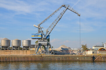 Container ship dock on the Main in Frankfurt with gray crane on the pier wall