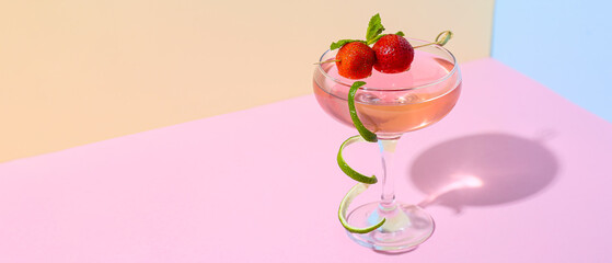 Glass of tasty cosmopolitan cocktail on color background with space for text
