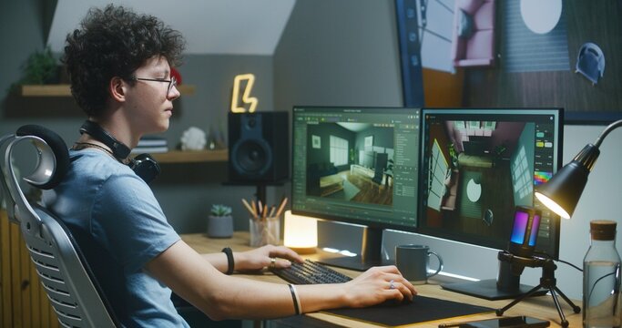 Young 3D designer creates modern house interior, works on design project at home office on computer and big digital screen with professional software interface and tools for 3D modeling and planning.