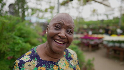 Fototapeta premium Portrait of a Brazilian older woman close-up face looking at camera standing inside a Green Environment