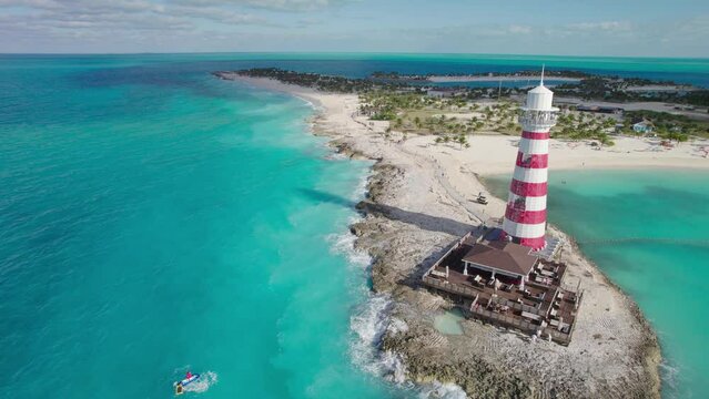 Flying Next to a Red White Lighthouse on a Peninsula of a Carribean Island with Blue Waters