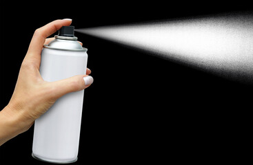 The dispersion jet from an aerosol can in feminine hand on dark background