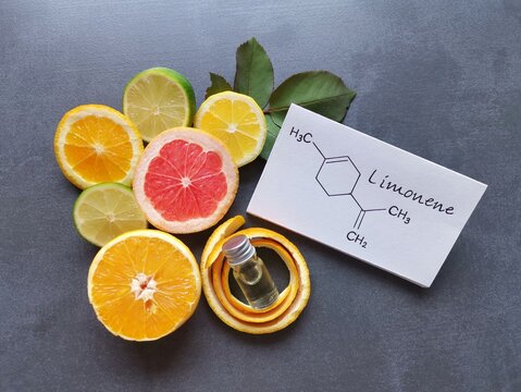 Structural chemical formula of limonene with fresh citrus fruit and a cosmetic glass bottle. Limonene is a terpene, found in the peels of citrus fruits, such as lemon, orange, grapefruit, lime.