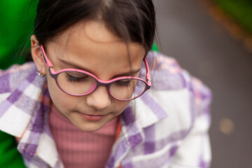 Portrait of a cute little girl wearing glasses and a plaid shirt