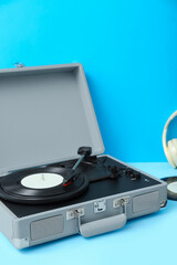 Record player with vinyl disk on blue table