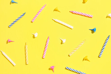 Colorful birthday candles on yellow background