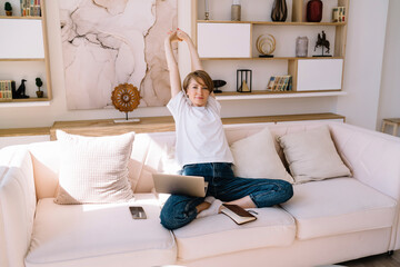 Content woman with netbook relaxing after studies at home