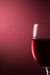 Red wine in a wineglass on red background, wine tasting, luxury and celebration concept