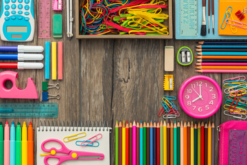 Back to school banner with colorful pencils and objects on a school desk, flat lay