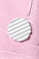 Plaster podium in water on pink background