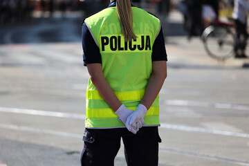 Policjantka ruchu drogowego w białych rękawiczkach kieruje ruchem drogowym w mieście. - obrazy, fototapety, plakaty