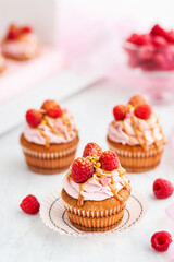 Delicious raspberry and caramel cupcakes on white background
