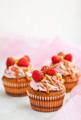 Delicious raspberry and caramel cupcakes on white background