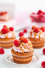 Delicious raspberry and caramel cupcakes on white background