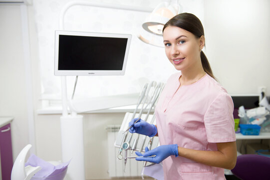 Happy young female dentist in medical office background. Stomatology and healthcare concept.