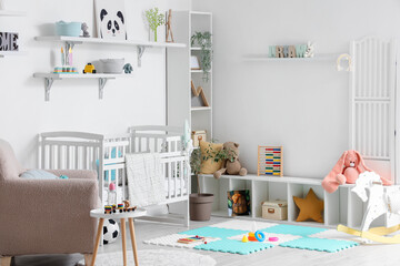 Stylish interior of children's room with baby bed and toys