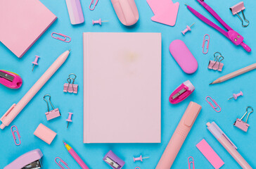Pink school stationery with notebook on color backgroung, top view