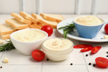 Bowls of tasty cream cheese on table
