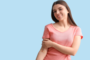 Female donor with applied medical patch on blue background