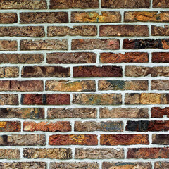 Background of Multi Colored Old Brick Wall with Cracked Surface and Concrete closeup Outdoors