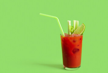 Glass of bloody mary with celery and lime on green background © Pixel-Shot