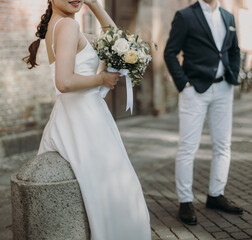 Groom wears blue suite and bride in white wedding dress. Bridal couple in love on a wedding day. - 615930978