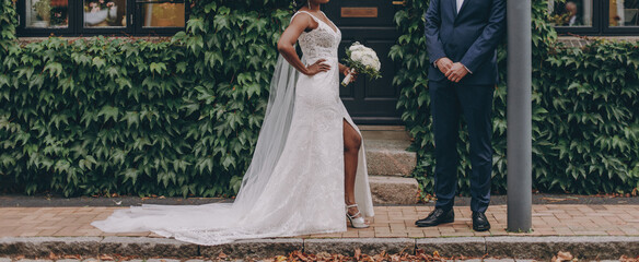Afro-american bride and caucasian groom posing on a wedding photo shoot - 615931106