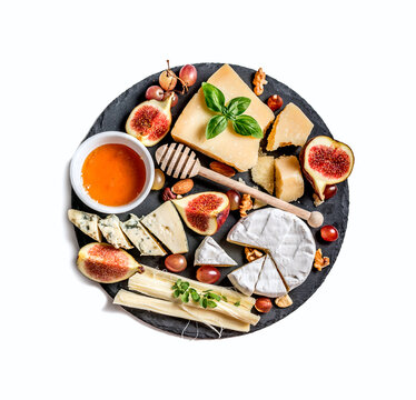 Cheese plate served with nuts and honey top view isolated