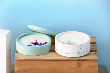 Holders with candles on table near blue wall in room, closeup