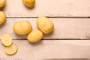 Raw baby potatoes on white wooden background