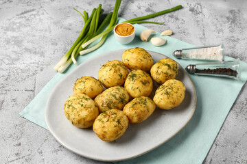 Plate of boiled baby potatoes with dill and mustard on grey background