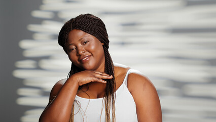 Smiling woman promoting self love in empowering ad, filming skincare campaign in studio. Natural girl with radiant appearance feeling flawless and confident on camera, bodycare.