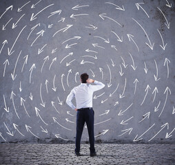Confused businessman looking a wall with directional arrows. concept of confusion - obrazy, fototapety, plakaty